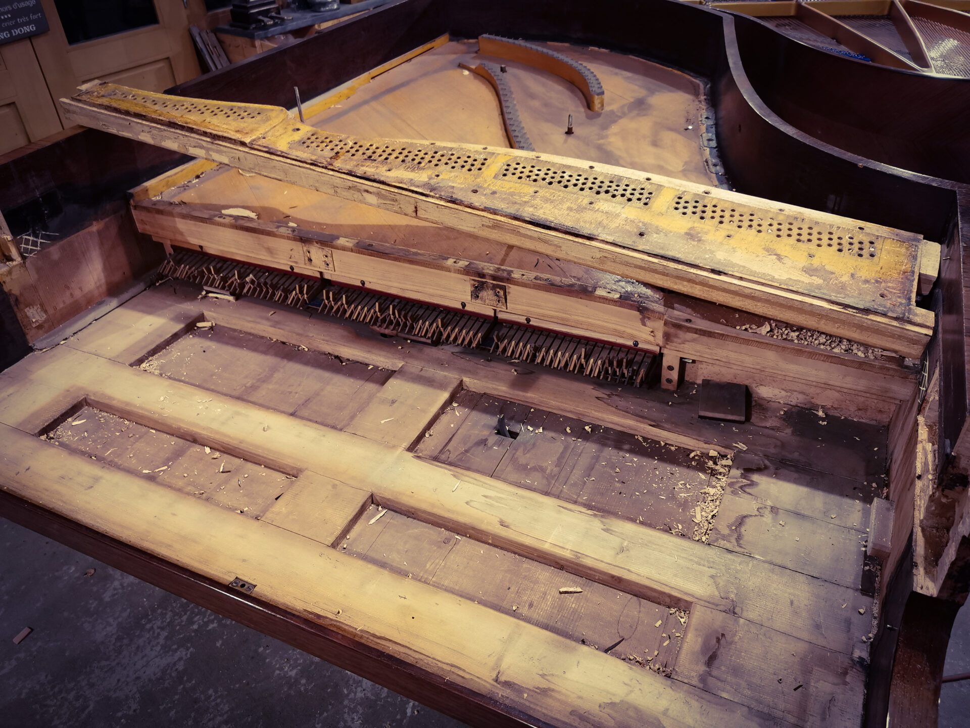 extraction du vieux sommier de piano demi queue Pleyel 2m04 de 1899 dans atelier de restauration de pianos de Marion Lainé en Savoie